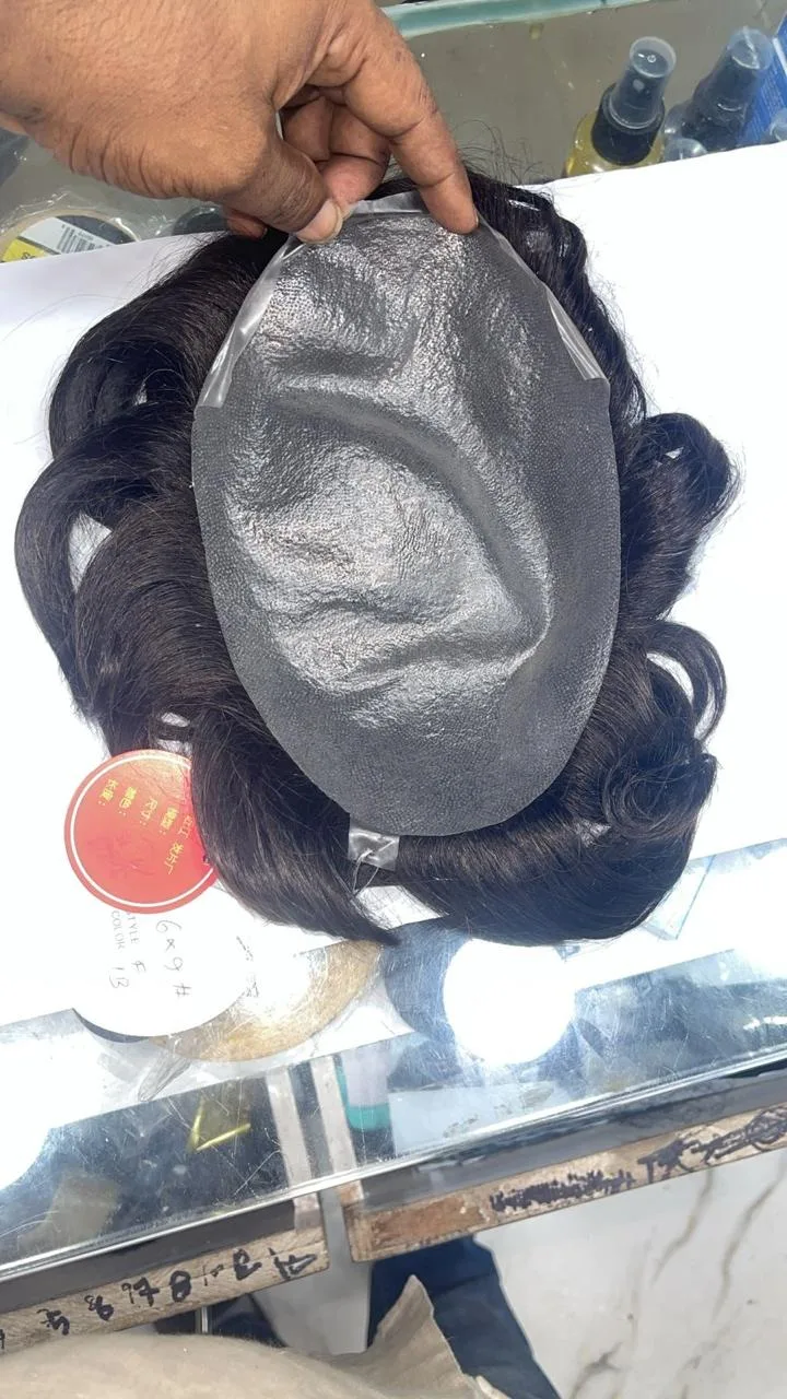 Close-up of the underside of a supplied hair system held in hand